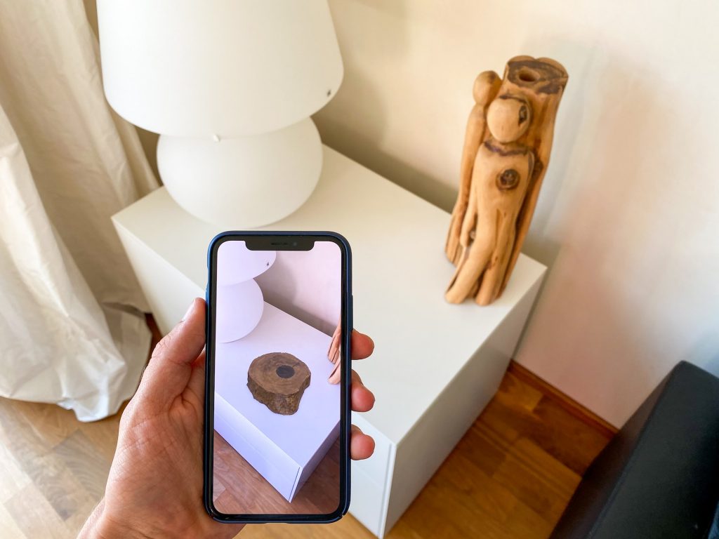 Man using Augmented Reality app on phone to visualise product on cupboard