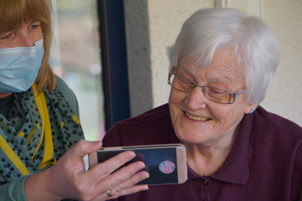 Old woman looking at a video on a smartphone