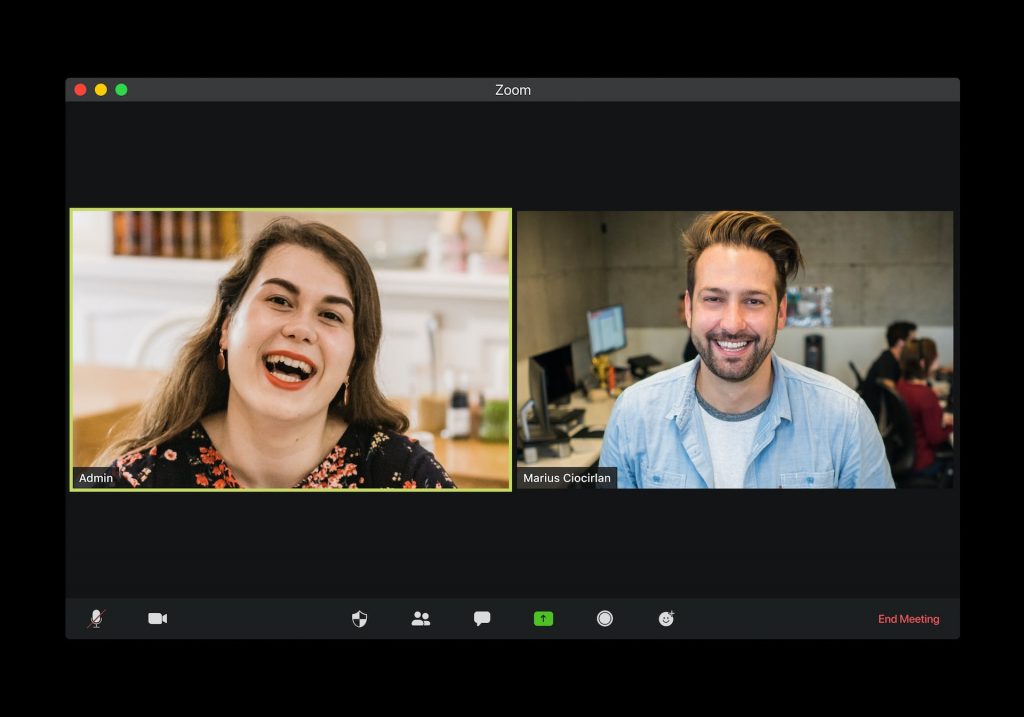 Zoom video conferencing software with two people laughing